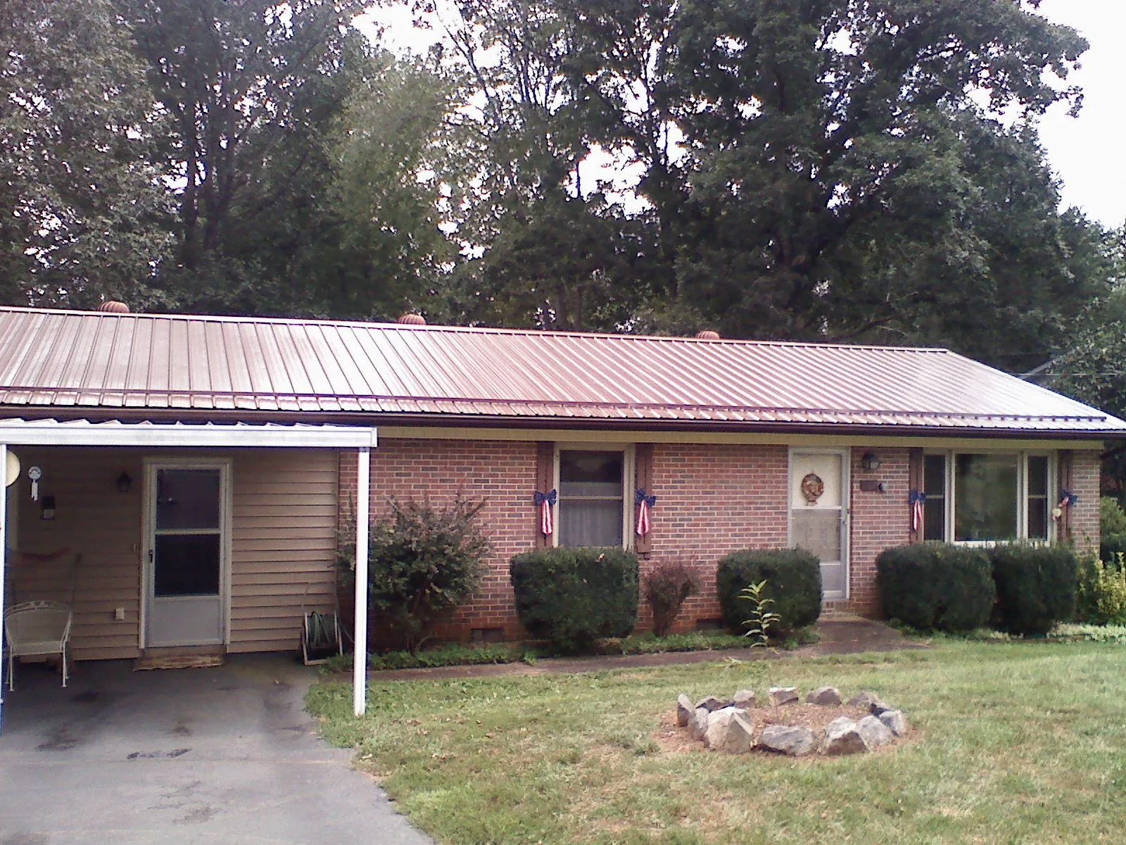 Bronze metal roof and carport on a brick ranch home — Roof Repair work by our crew in Stoneville