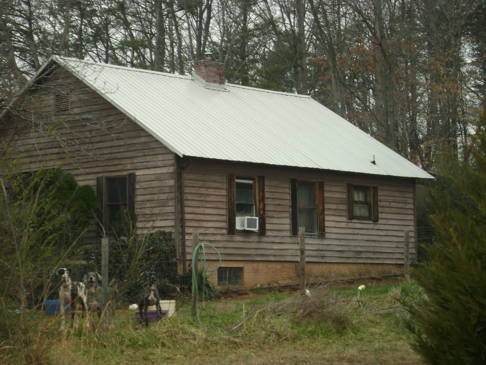 White metal roof on an old wood sided farmhouse, from a Metal Roof Installation job in Stoneville